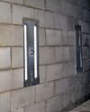 an inside view of foundation wall anchors installed along a basement wall to brace and repair the structure in Dunn