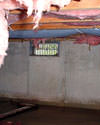 North Carolina crawl space with vents, showing mold, rot, and fiberglass insulation dripping off the ceiling.