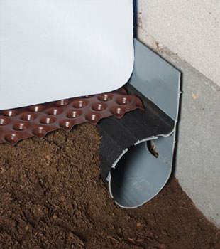 Closeup of a crawl space drainage system installed in Hubert