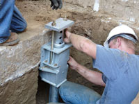 Foundation repair contractors installing the foundation bracket in Greenville.
