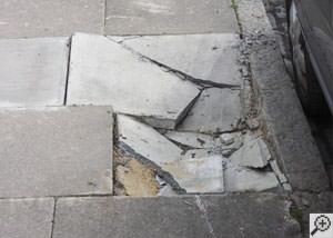 photo of a sinking concrete sidewalk with cracks in Spring Lake