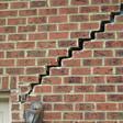 stair step cracking reaching from a window along the foundation wall in Greenville