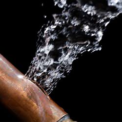 A bursting copper pipe in Jacksonville, with water gushing out.