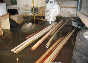 A severely flooding basement in Camp Lejeune, with lumber and personal items floating in a foot of water