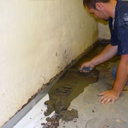 A basement waterproofer installing a perimeter drain system in Laurinburg
