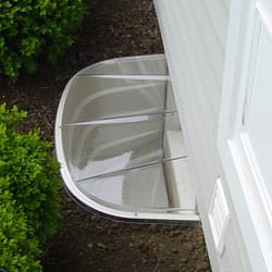 A vinyl basement window and covered window well in Supply