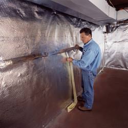 Installation of a radiant heat and vapor barrier on a basement wall in Saint Pauls