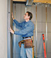 Insulated basement wall panels being placed against a concrete foundation wall in Wrightsville Beach